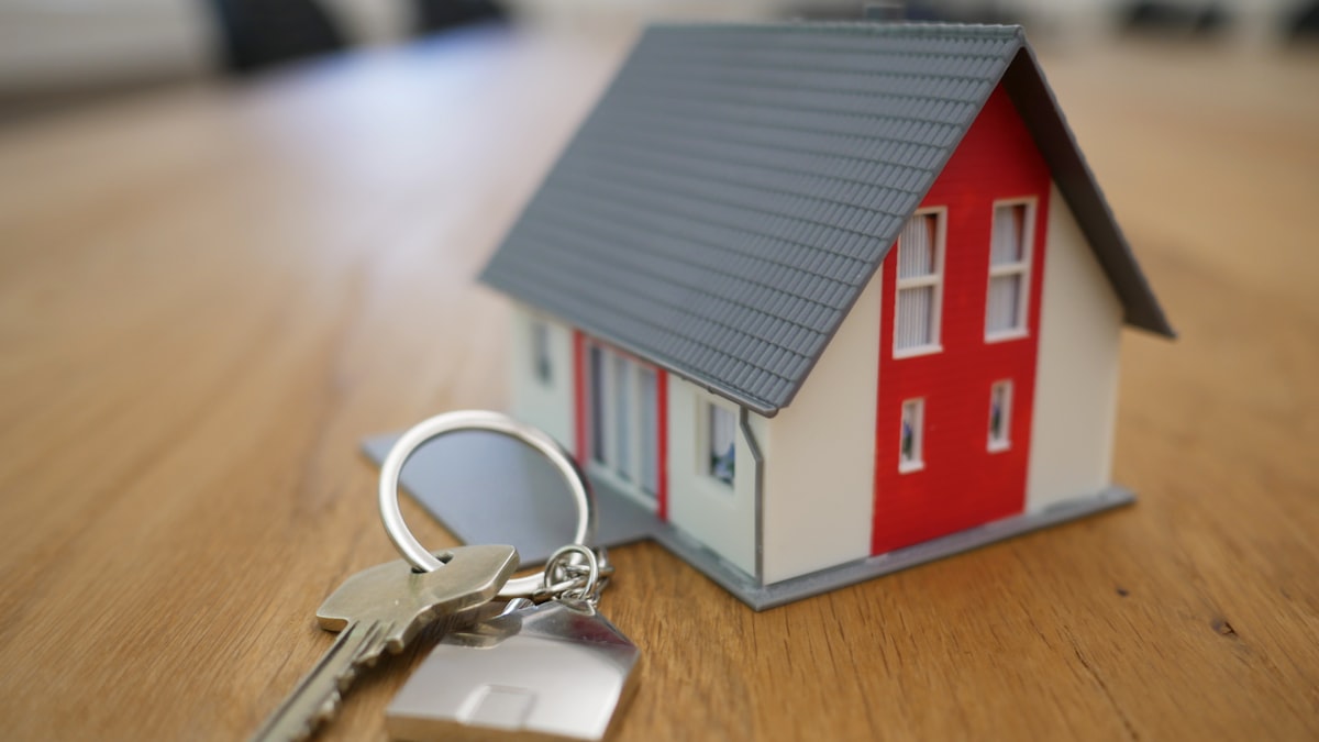 Model home with keys resting on a solid wood desk