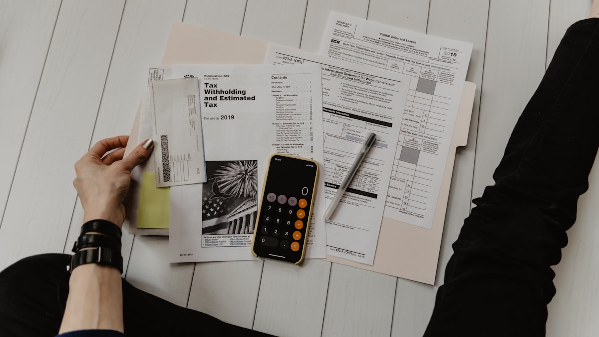 Official tax withholding documents, calculator, pen and financial papers